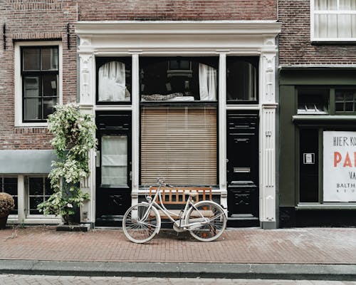 棕色的自行车停在黑白混凝土建筑旁边