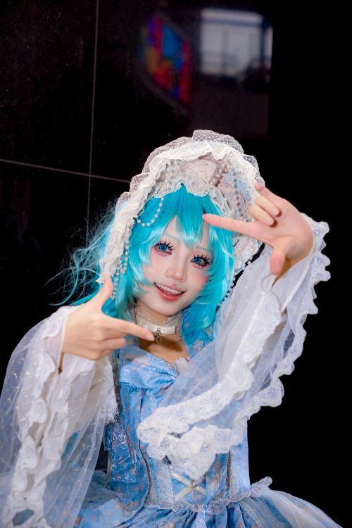 Free Vibrant anime cosplay portrait featuring a character with blue wig and elaborate lace costume, indoors. Stock Photo