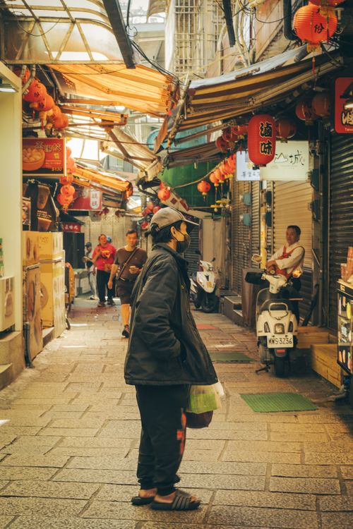 Free Vibrant street market with people, scooters, and hanging lanterns in an Asian alleyway. Stock Photo