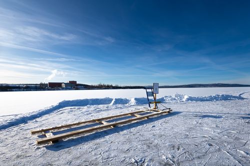 Free Sled on a frozen lake in Ludvika, Sweden, under a clear blue winter sky. Stock Photo