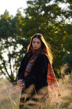 Portrait of a young woman outdoors in autumn with colorful scarf.
