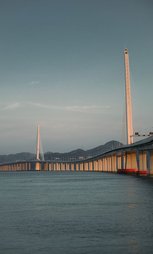 Free Elegant cable-stayed bridge at sunset over calm blue waters, showcasing modern engineering. Stock Photo