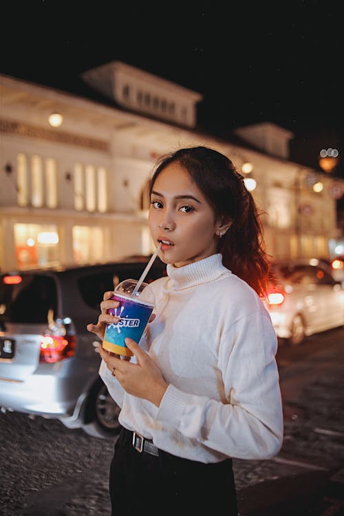 Gadis Dengan Sweater Putih Memegang Minuman