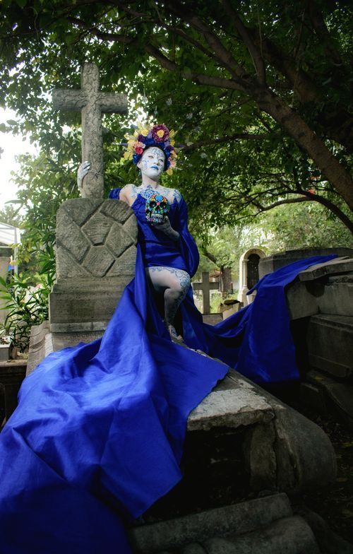 Free A person in vibrant Día de los Muertos costume posing in a Mexican cemetery. Stock Photo