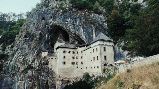 Explore the fascinating Predjama Castle, nestled within a dramatic cliff face in Slovenia.