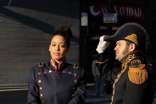 Free Portrait of two adults in historical attire, one saluting, lit by daylight. Stock Photo