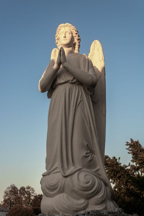 Free A peaceful angel statue with folded hands captured during sunset in Braslav, Belarus. Stock Photo
