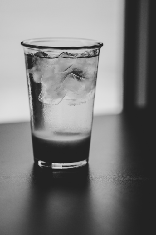 Free Monochrome image of a refreshing glass of ice water on a table. Stock Photo