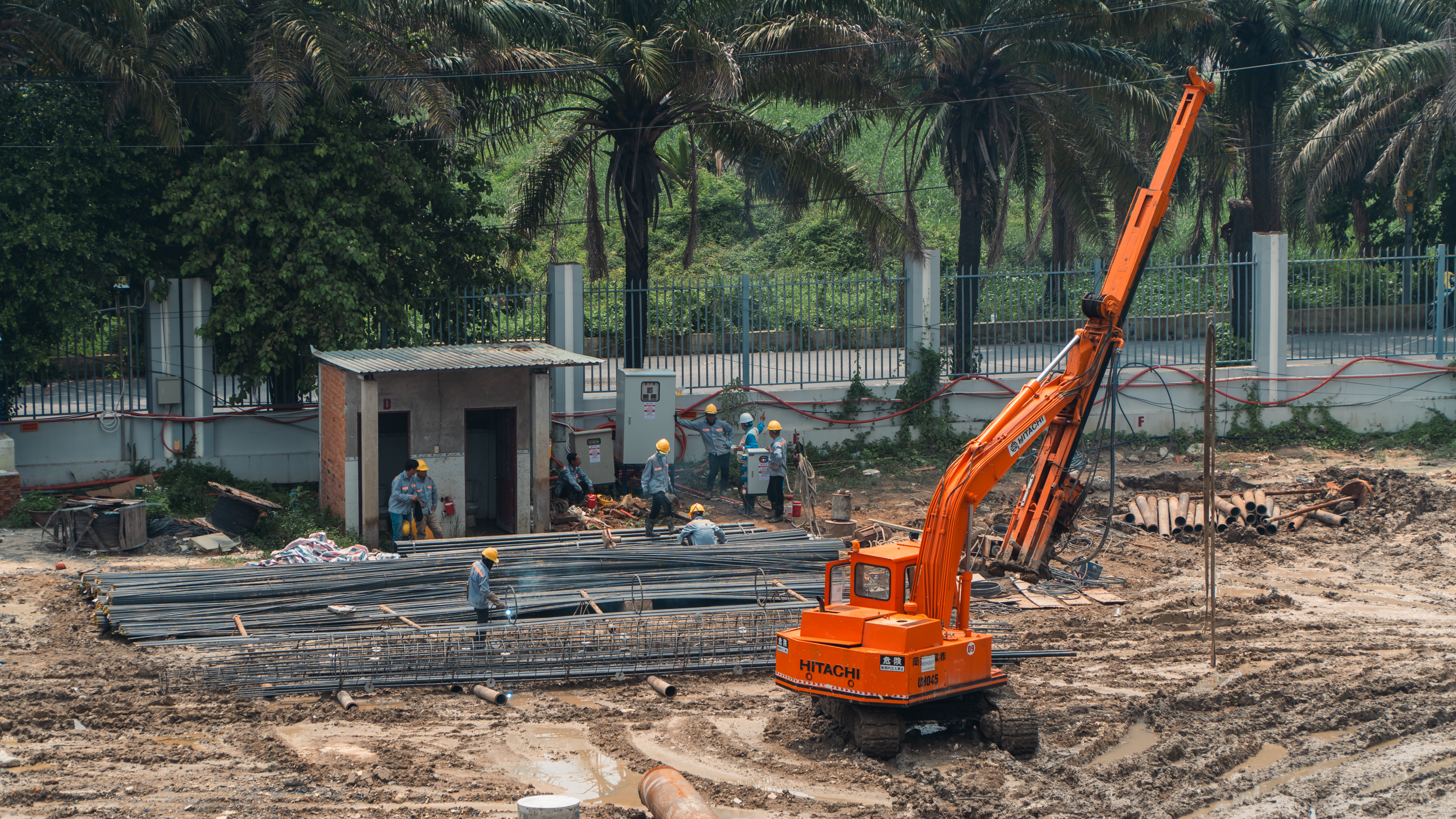 Busy construction site with workers and an orange excavator.