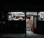 夜晚，便利店的灯光从内部透出，照亮了店外