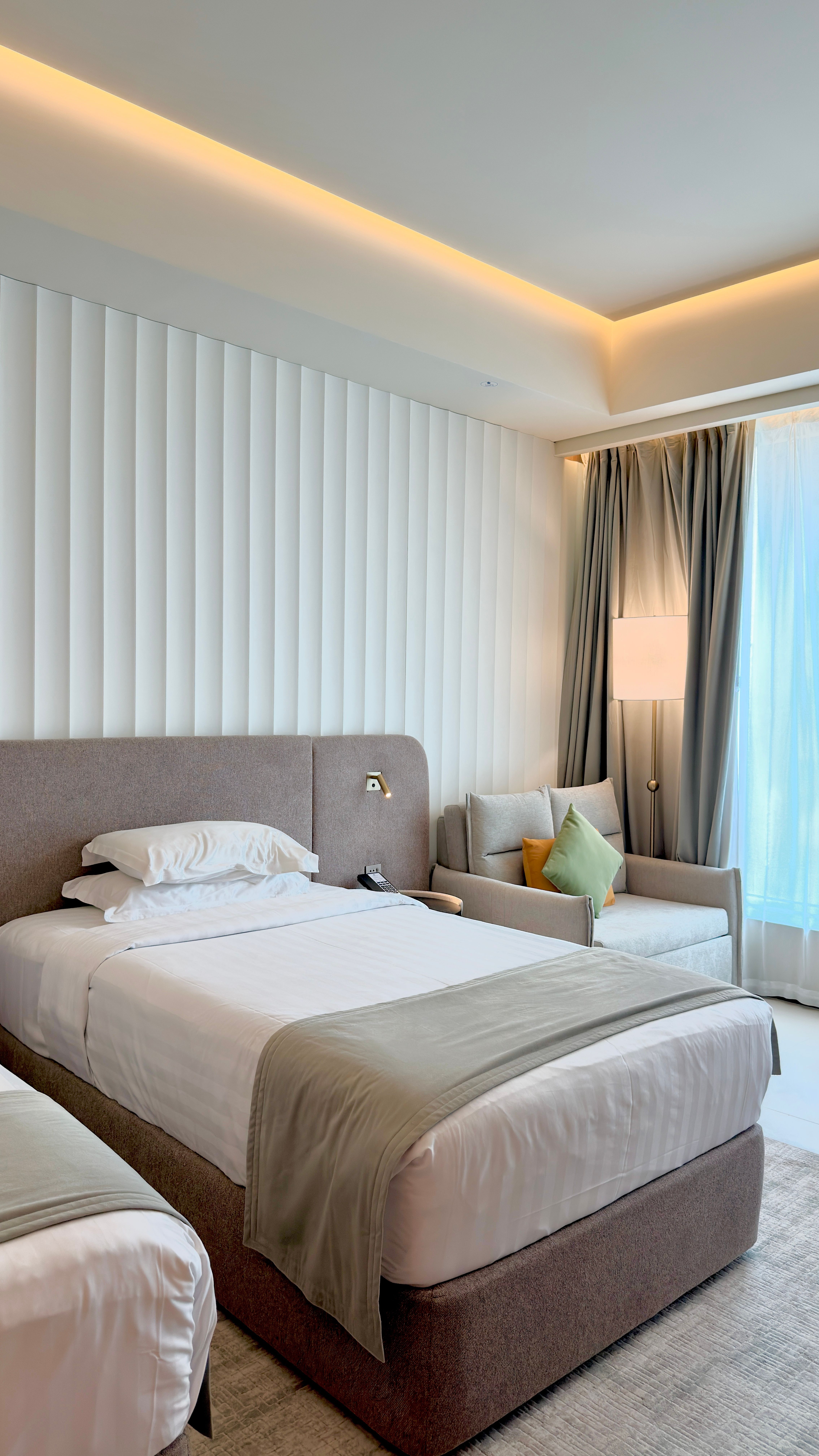 a tidy single bed room with window light