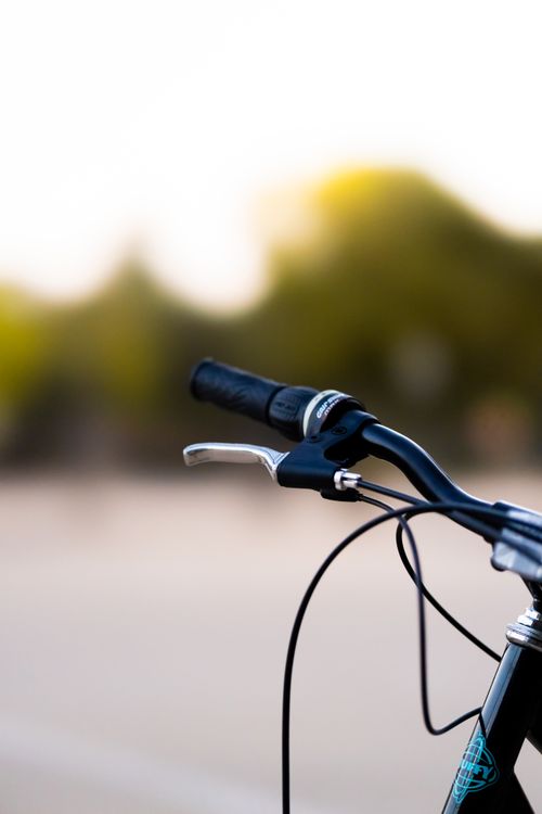 Free Stylish blurred background focusing on bicycle handlebars highlighting urban adventure. Stock Photo