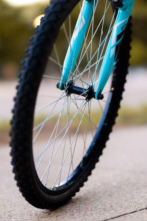 Free Detailed image of a bicycle tire and fork on a sunny day, highlighting spokes and tread. Stock Photo