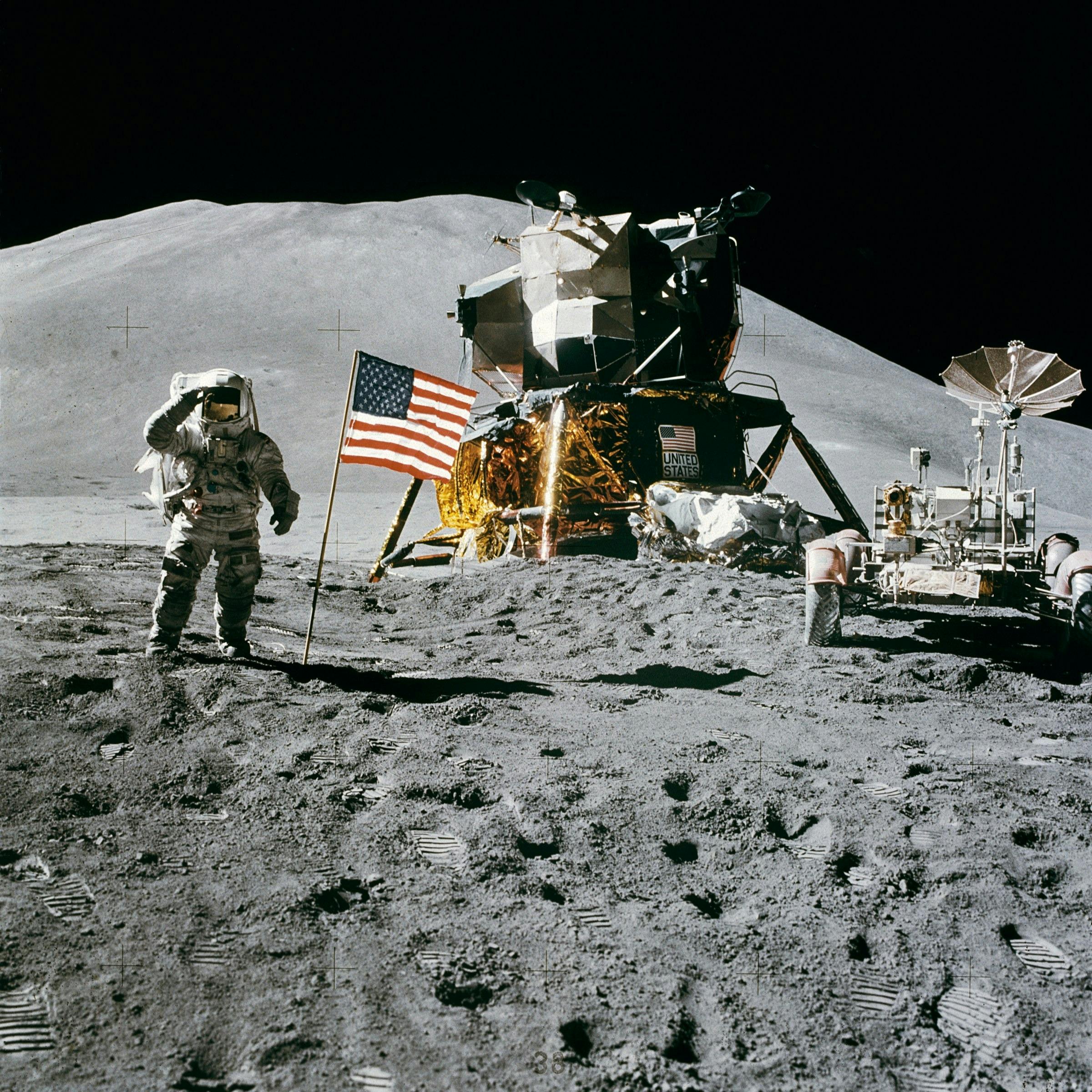 月のアメリカ国旗の横に立っている宇宙飛行士 無料の写真素材