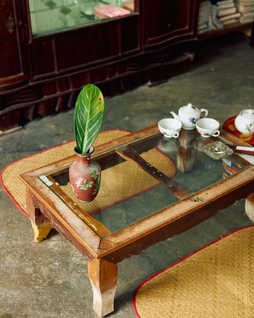 Free A rustic Vietnamese living room with a traditional tea set and vase on a wooden table. Stock Photo