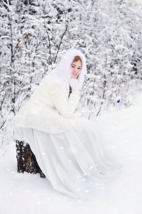 Bezpłatne Kobieta W Białej Futrzanej Sukience Z Kapturem W Białym śniegu Złożony Zdjęcie z galerii