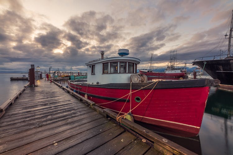 Red And White Boat On Dock Under Cloudy Sky