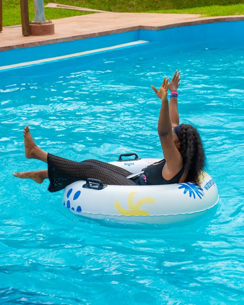 Free Woman relaxing in a swimming pool on an inflatable ring during a summer day. Stock Photo