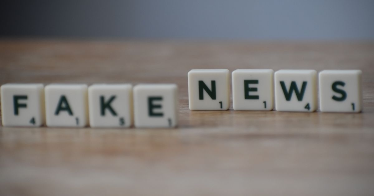 Letter tiles spelling fake news, representing AI-generated misinformation and brand risk.