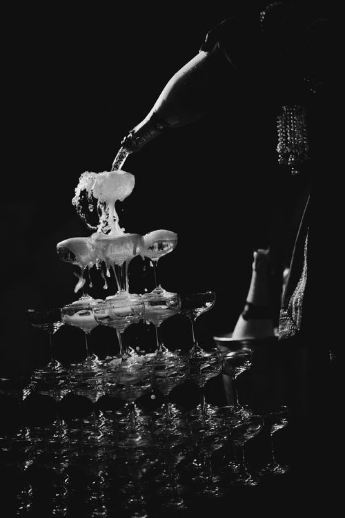 Free Black and white photo of champagne pouring into a glass tower at an event. Stock Photo