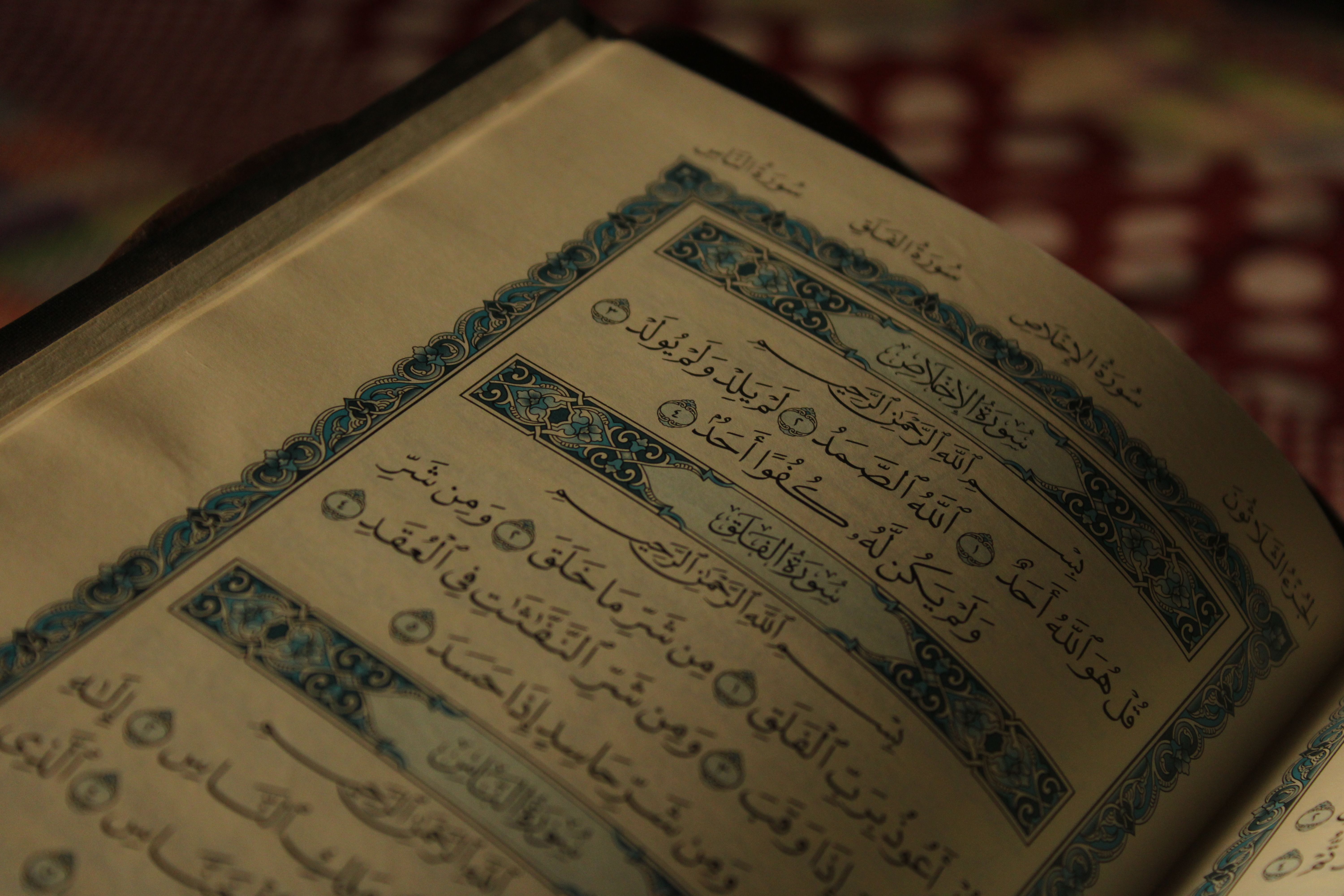 An open Quran showing intricate Arabic calligraphy and decorative designs.
