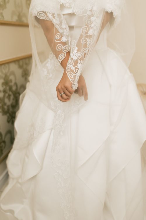 Free Close-up of a bride in a white dress with lace veil before wedding ceremony. Stock Photo