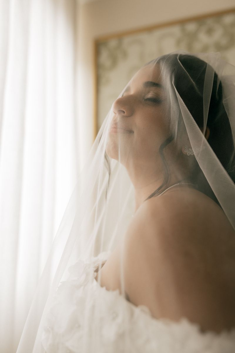 Bride in veil bathed in soft window light