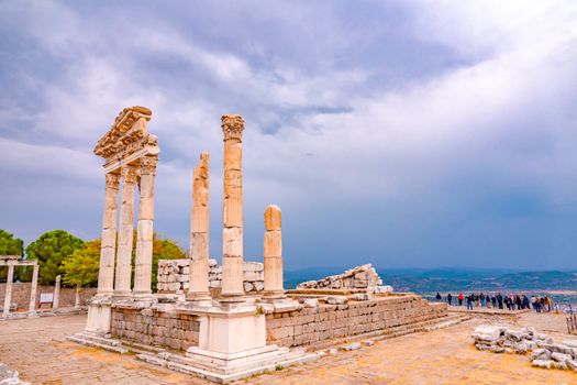 View of the ancient ruins of Pergamon Temple against a dramatic cloudy sky in Turkey.