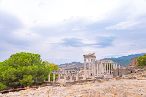 Free Panoramic view of the ancient ruins of Pergamon with cloudy sky and lush greenery. Stock Photo