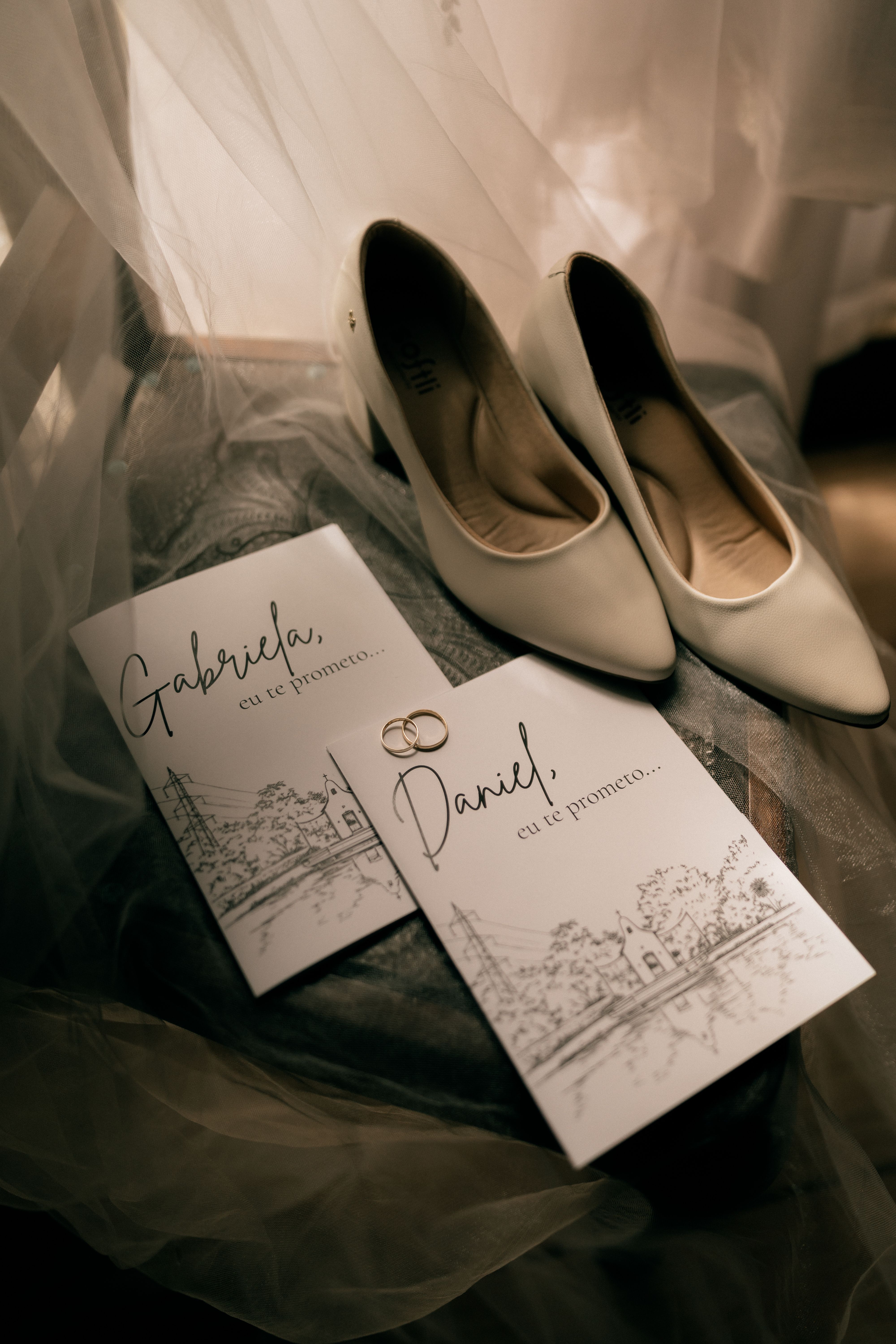 Elegant wedding scene depicting vows, white shoes, and rings under romantic lighting.