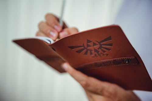 Person Holding Red Planner