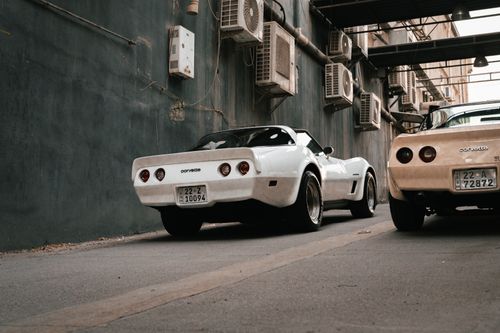 Free Two vintage white Corvette cars parked in an urban alleyway in Erbil, Iraq. Stock Photo