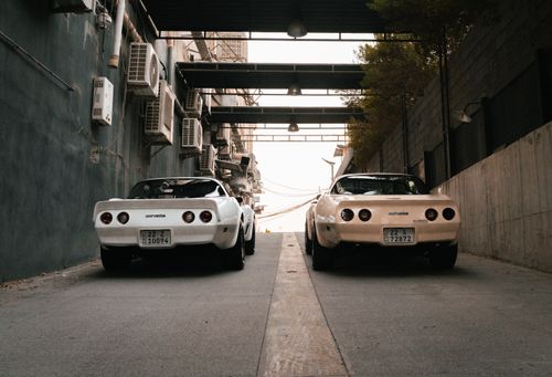Free Two vintage cars parked in a dimly lit urban alleyway in Erbil, Iraq, creating a nostalgic ambiance. Stock Photo