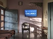 Black Flat Screen Tv Turned on Near Green Plastic Armchair