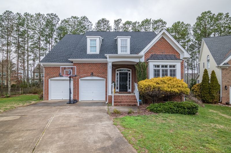 Red-brick suburban home with an arched double garage — photo by Curtis Adams on Pexels