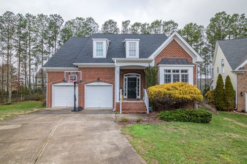 Free Brick suburban home with garage and basketball hoop in a peaceful neighborhood. Stock Photo