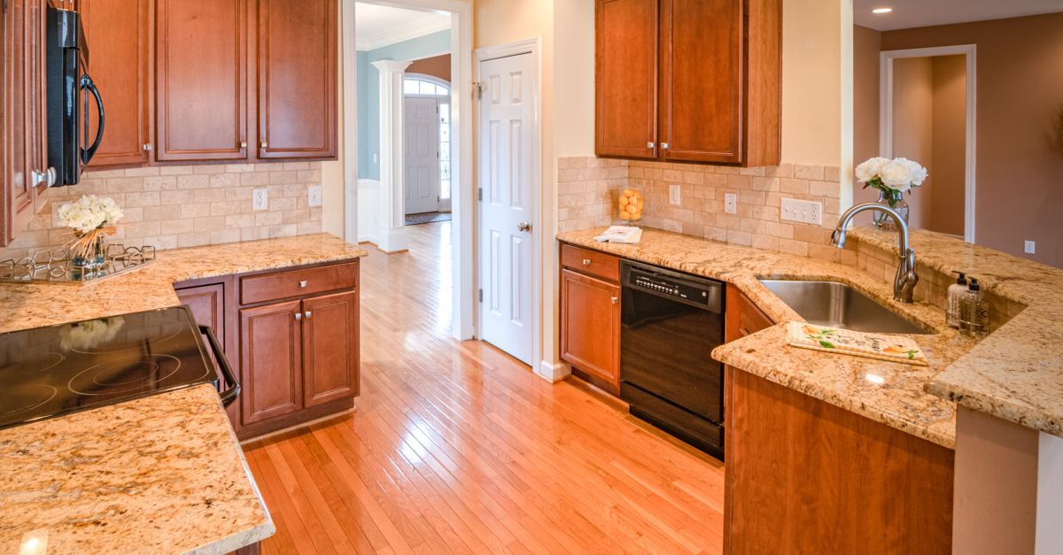 Bright kitchen interior with wooden cabinets and granite countertops.