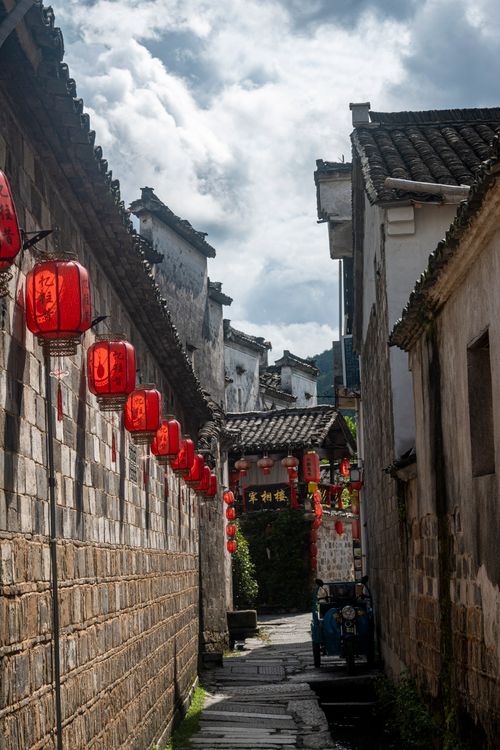 Free Picturesque alley with red lanterns in a historic Chinese town, showcasing traditional architecture. Stock Photo