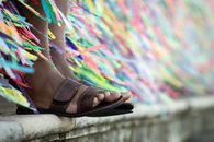 Close-up of colorful ribbons and sandals on the steps of a landmark in Salvador, Brazil.
