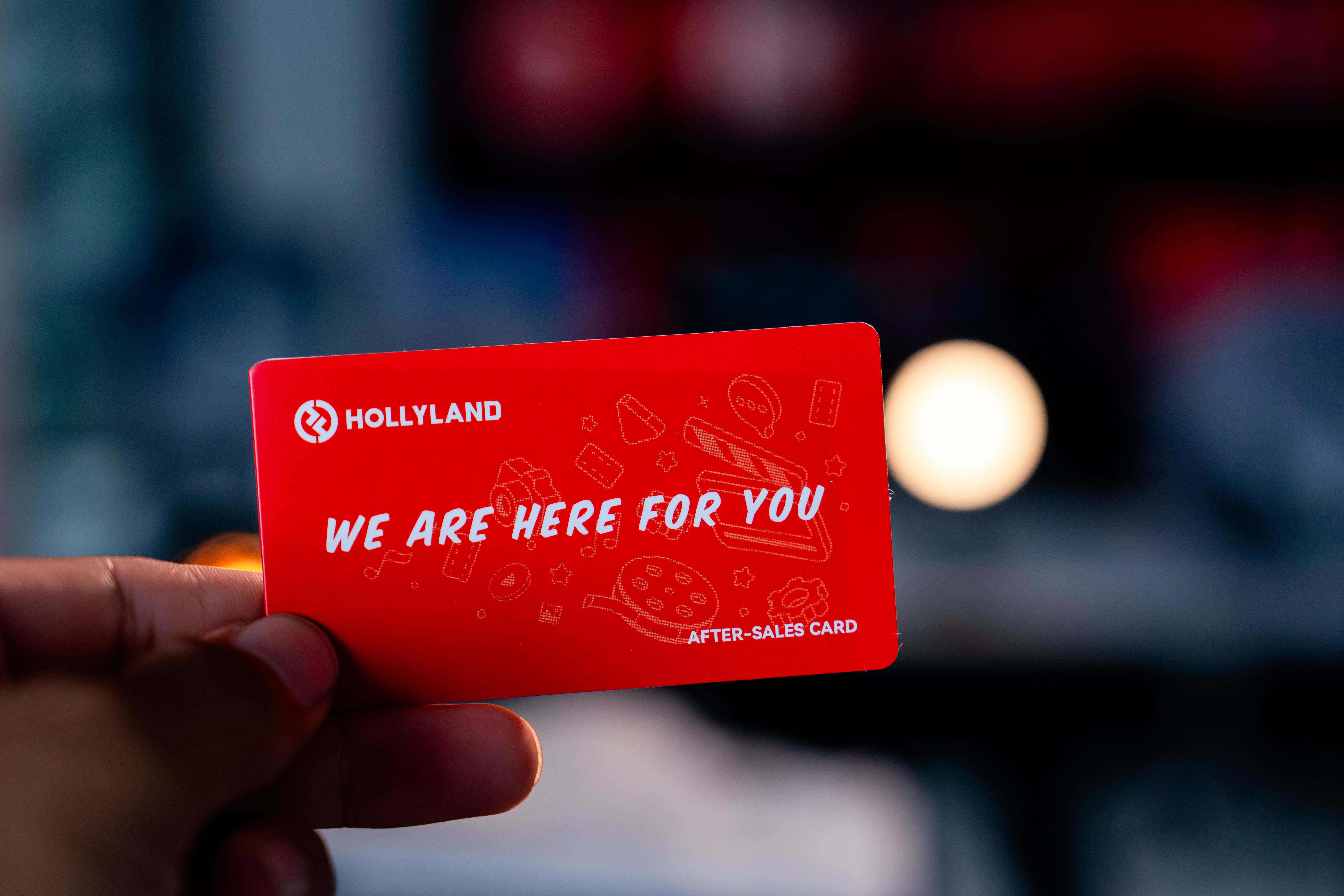 Vibrant after-sales card featuring 'We Are Here For You' message held indoors.