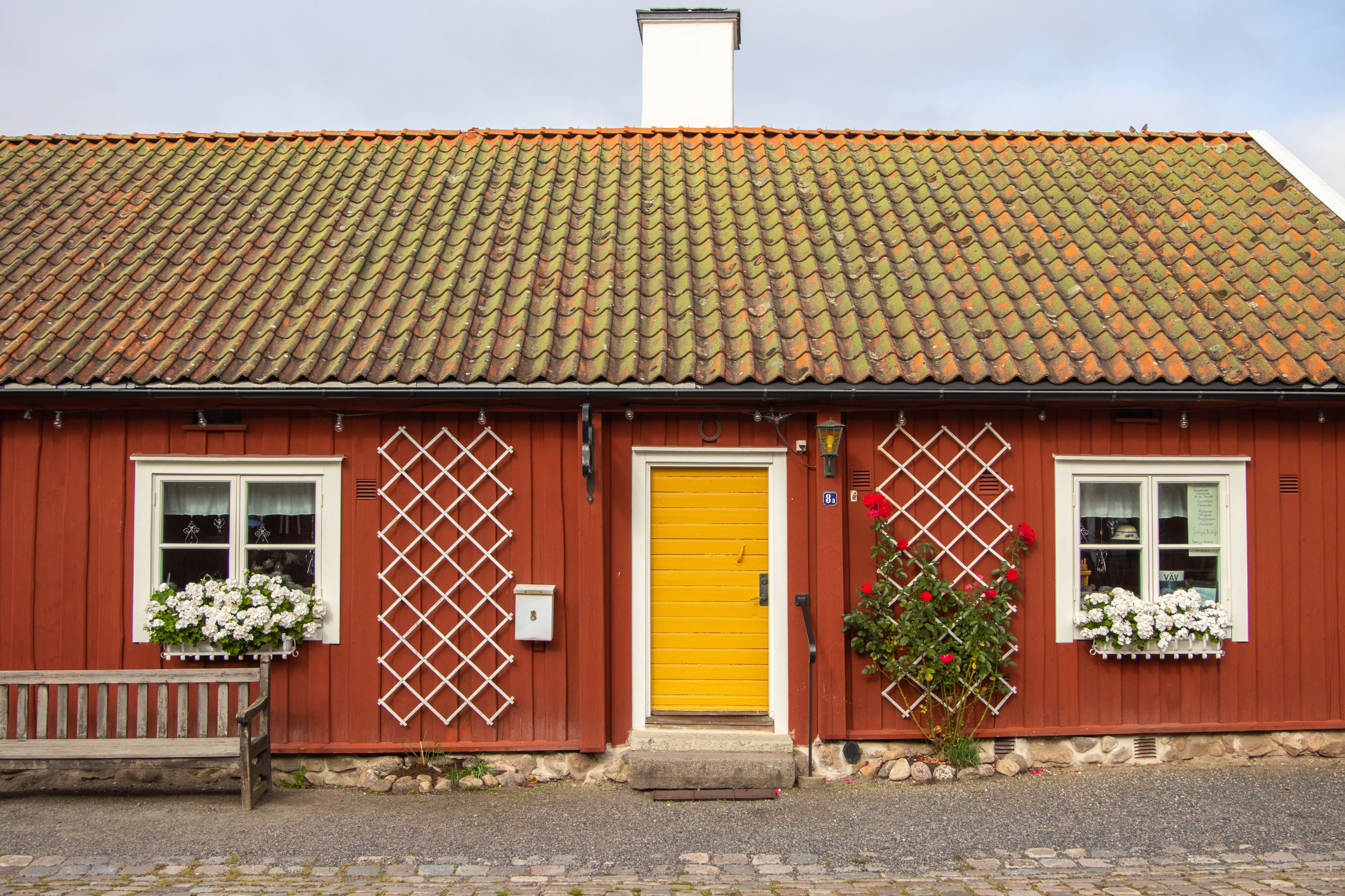 Cozy Swedish cottage with vibrant red walls and a yellow door in Jönköping, Sweden.