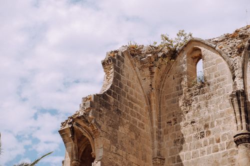 Free Aged stone ruins with arches set against a partially cloudy sky, showcasing historic architecture. Stock Photo