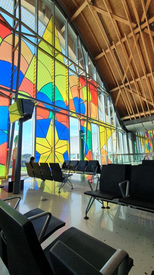 Free Colorful stained glass windows illuminate the seating area of a modern airport terminal. Stock Photo