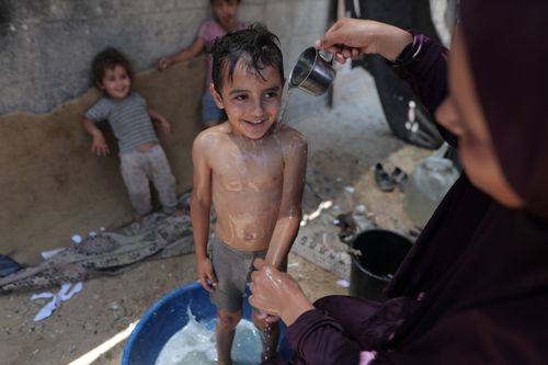 Free A joyful scene of children playing during a refreshing outdoor bath, capturing childhood innocence. Stock Photo