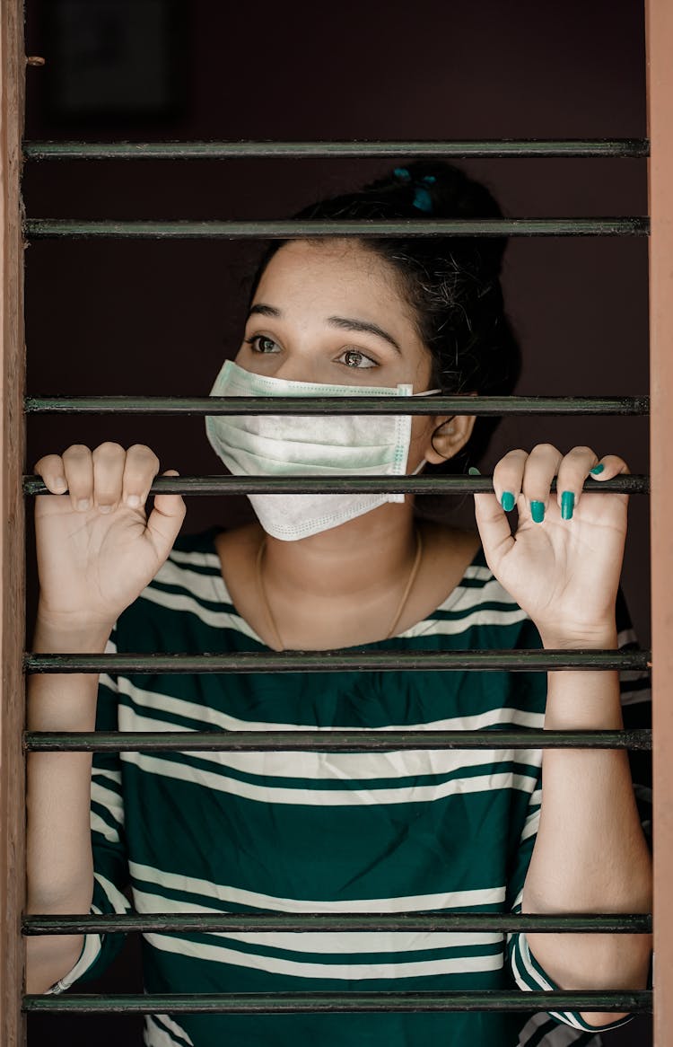 Woman In Green And White Stripe Shirt Covering Her Face With White Mask