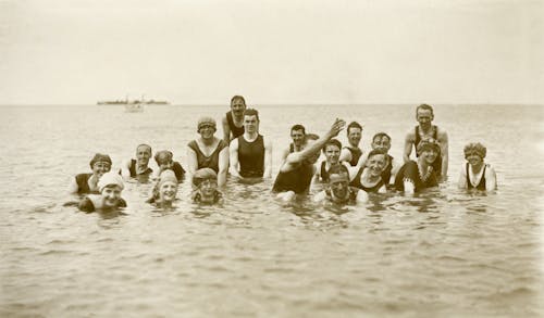 Фотография группы людей на воде в оттенках серого