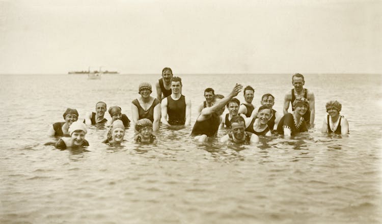 Grayscale Photo Of Group Of People On Water