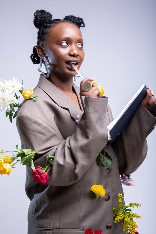 Free Creative artistic portrait of a woman with a floral blazer and notebook, expressing unique fashion. Stock Photo