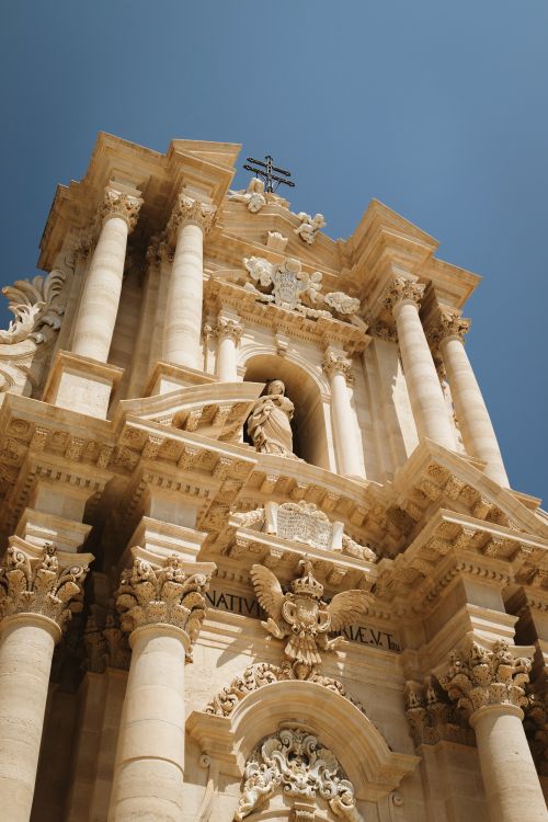 Free A stunning upward view of the Baroque-style Syracuse Cathedral facade under a clear sky in Sicily. Stock Photo