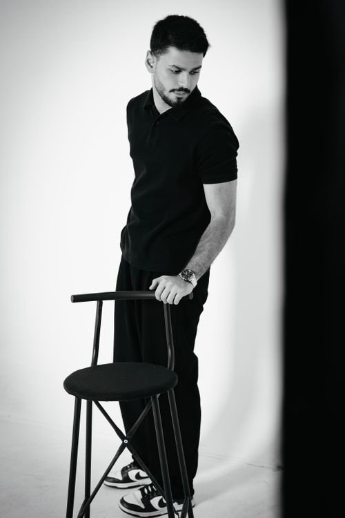 Free A black and white studio portrait of a stylish male model in a contemplative pose. Stock Photo